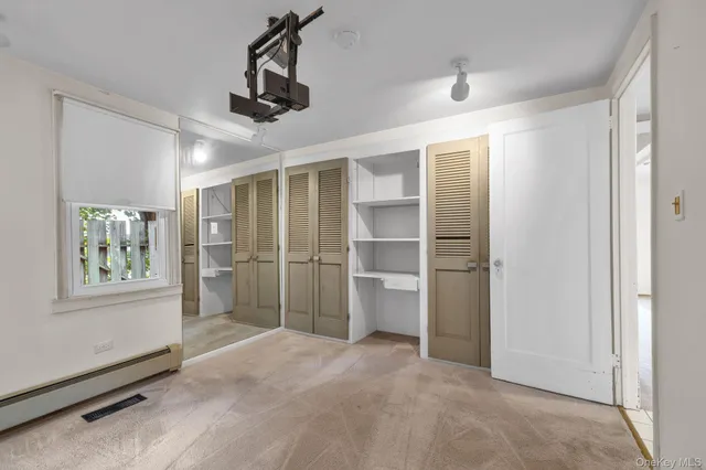 a view of empty room with cabinet and ceiling fan