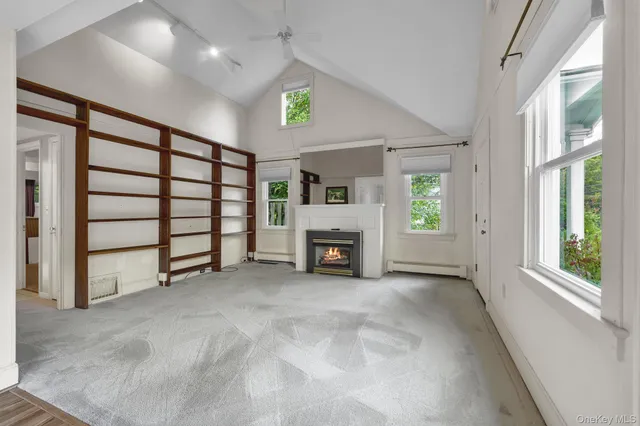 a view of an empty room with a fireplace and a window
