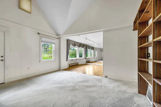 a view of an empty room with a window and closet