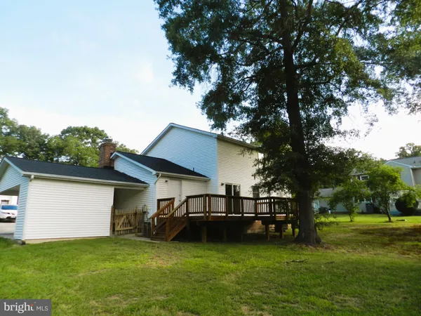 a view of a house with a yard and a large tree