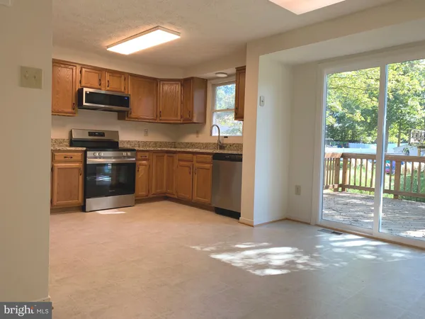 a kitchen with stainless steel appliances granite countertop a stove top oven a sink and dishwasher