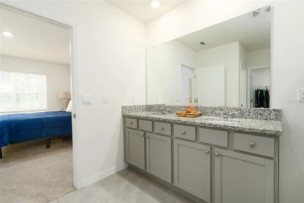 a bathroom with a granite countertop sink and a mirror
