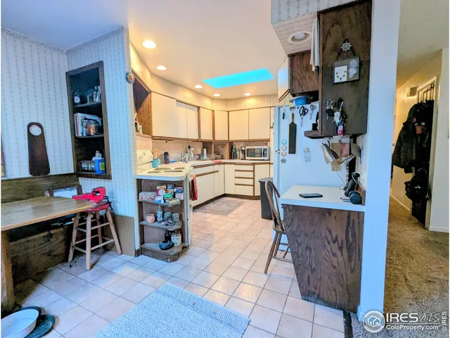 a view of a kitchen with fridge and workspace