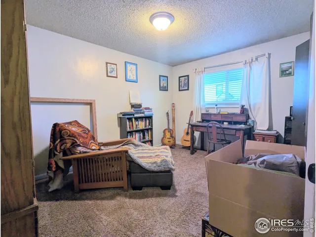 a bedroom with furniture and a large window