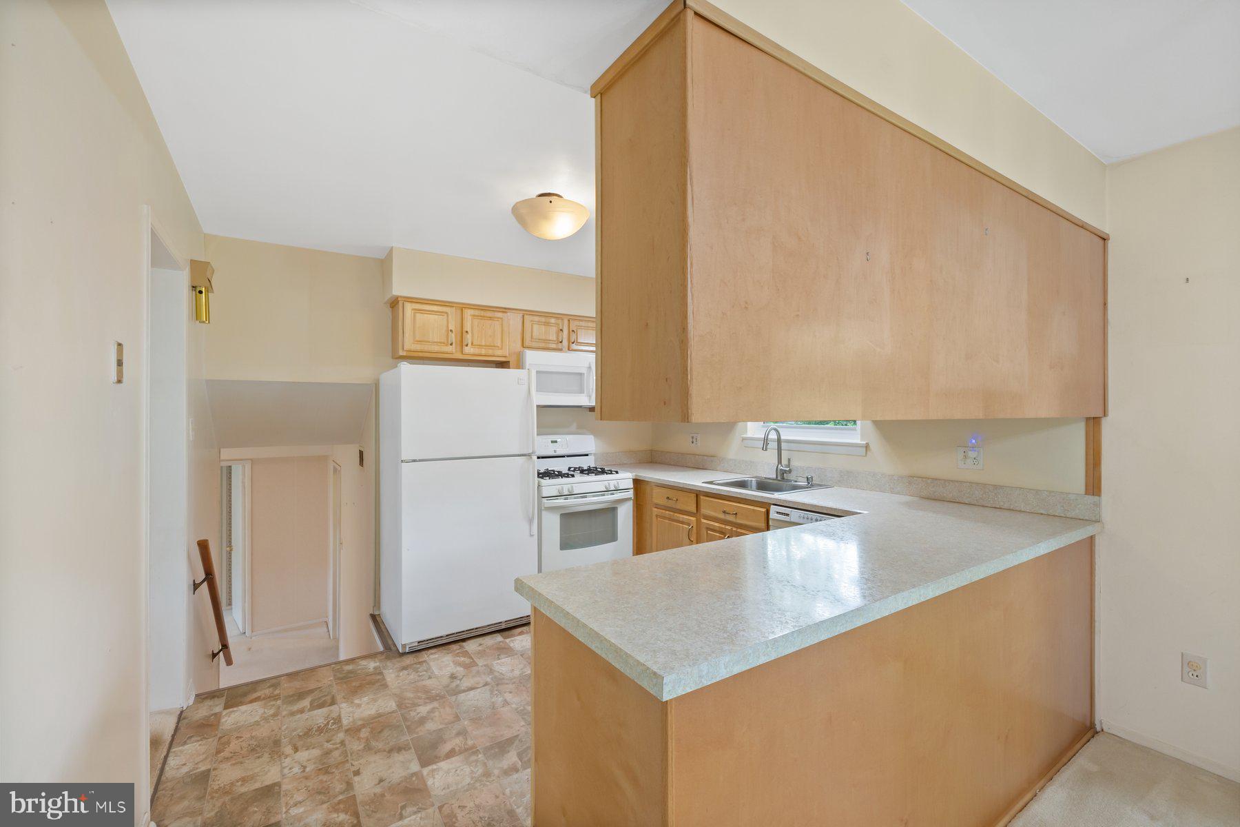 5304 Moultrie Road Springfield, VA 22151 - Photo 12 of 38 a kitchen that has a sink and a refrigerator