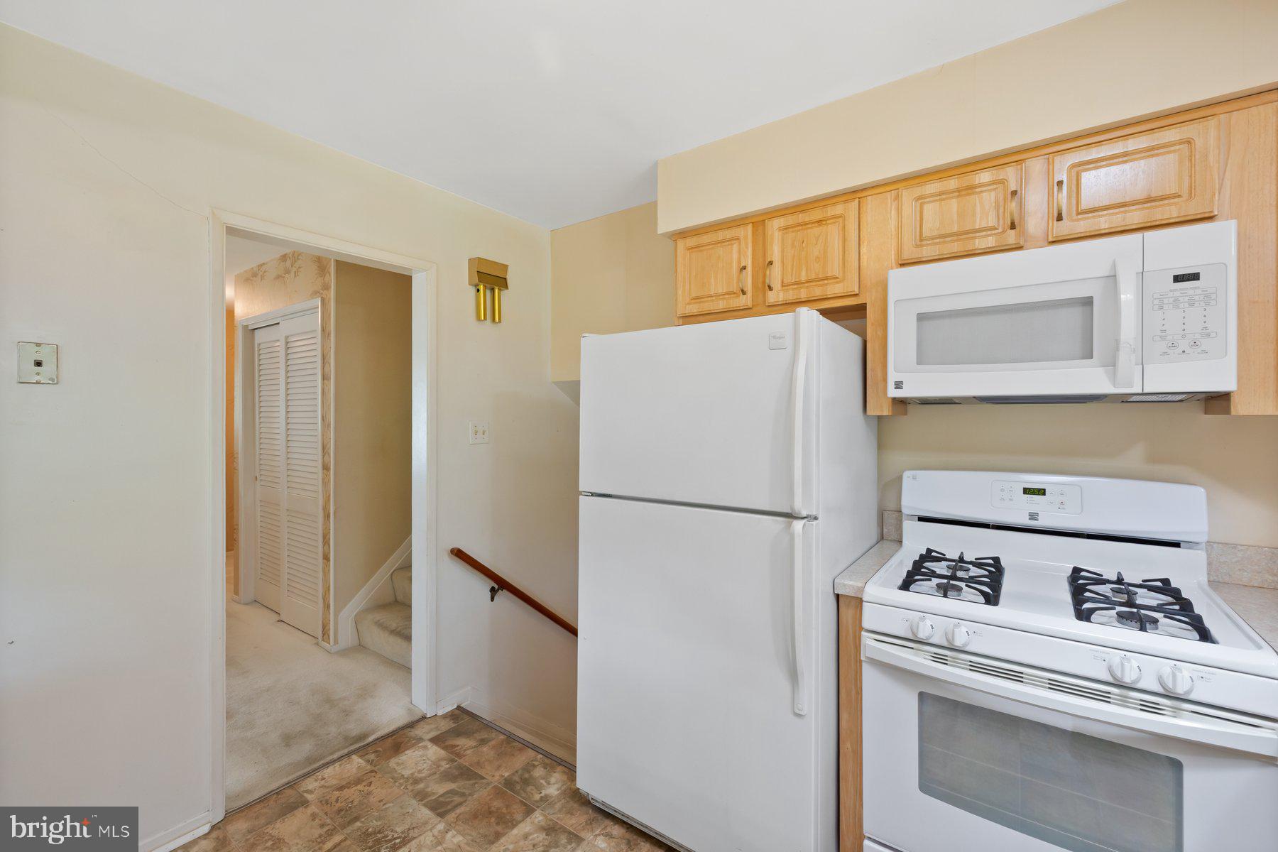 5304 Moultrie Road Springfield, VA 22151 - Photo 10 of 38 a white refrigerator freezer and a stove sitting inside of a kitchen