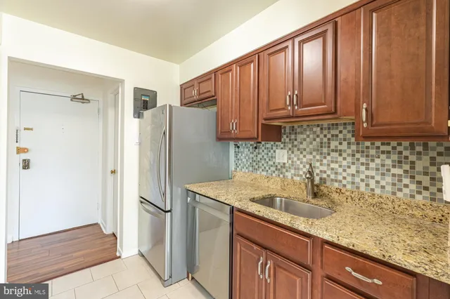 a kitchen with stainless steel appliances granite countertop a refrigerator and a sink