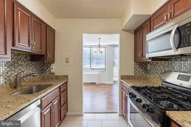 a kitchen with granite countertop a sink stove and cabinets