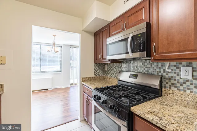 a kitchen with stainless steel appliances granite countertop a stove and a microwave