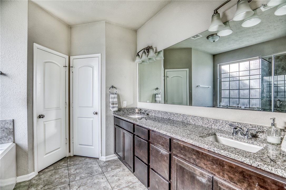 1827 Basin Trail Brenham, TX 77833 - Photo 14 of 38 a bathroom with a granite countertop sink and a mirror