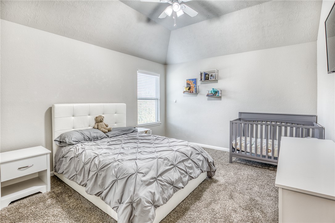 1827 Basin Trail Brenham, TX 77833 - Photo 20 of 38 a bedroom with a bed and a chandelier
