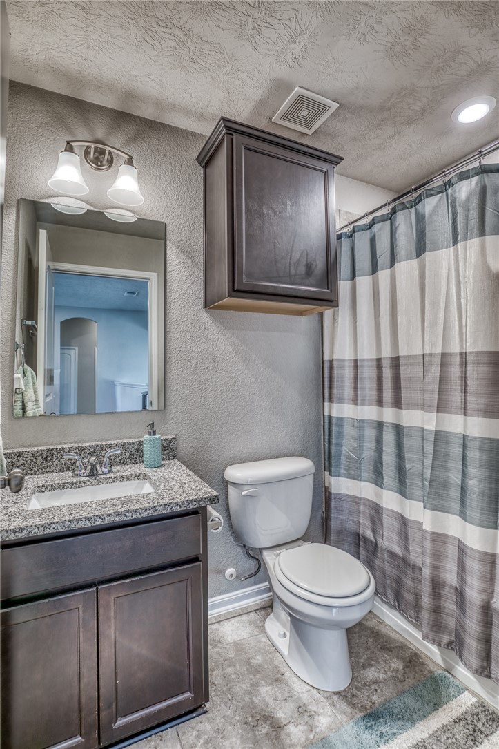 1827 Basin Trail Brenham, TX 77833 - Photo 21 of 38 a bathroom with a granite countertop toilet sink and mirror