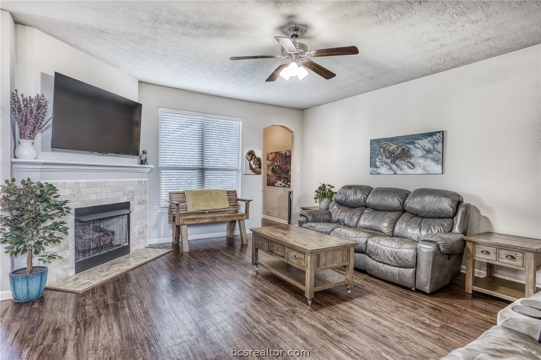 1827 Basin Trail Brenham, TX 77833 - Photo 6 of 38 a living room with furniture a fireplace and a flat screen tv