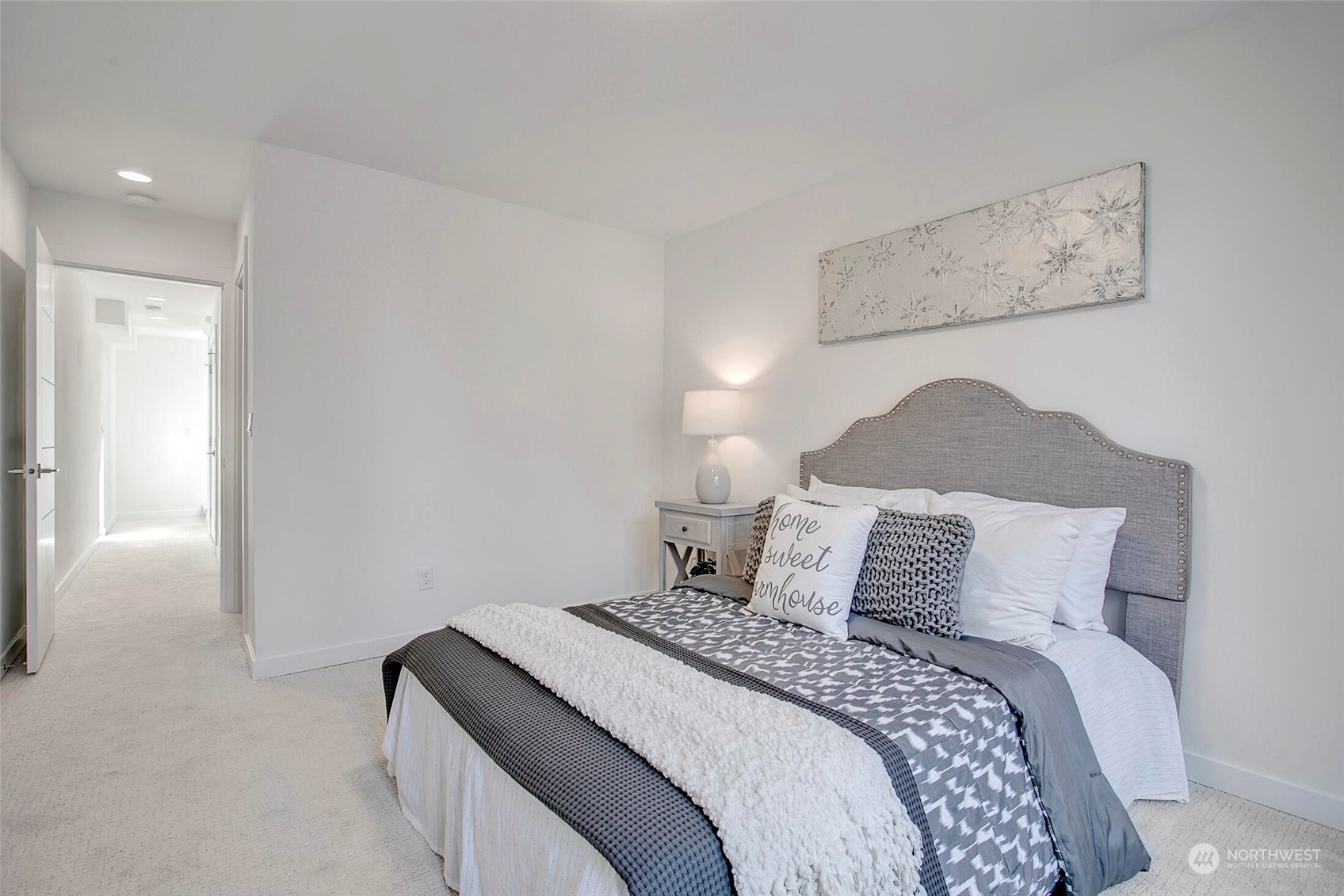 10170 Holman Road Northwest, Unit F Seattle, WA 98133 - Photo 12 of 22 a bedroom with a bed and a painting on the wall