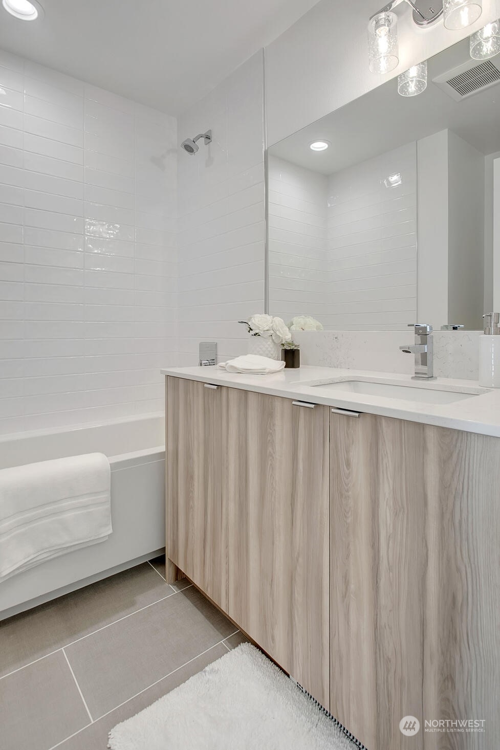10170 Holman Road Northwest, Unit F Seattle, WA 98133 - Photo 17 of 22 a bathroom with a bathtub a sink and a mirror
