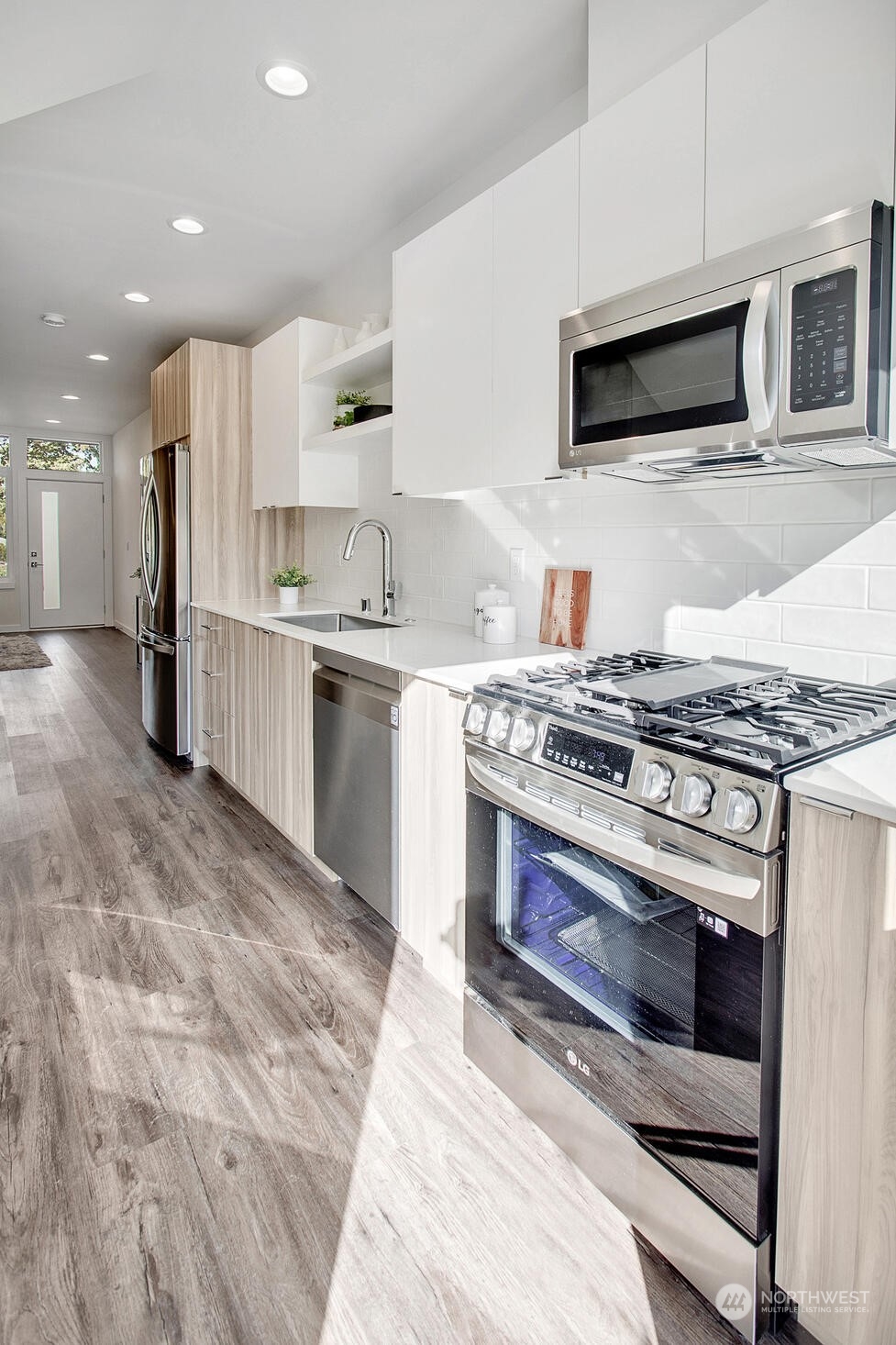 10170 Holman Road Northwest, Unit F Seattle, WA 98133 - Photo 2 of 22 a kitchen with stainless steel appliances granite countertop a stove top oven and sink