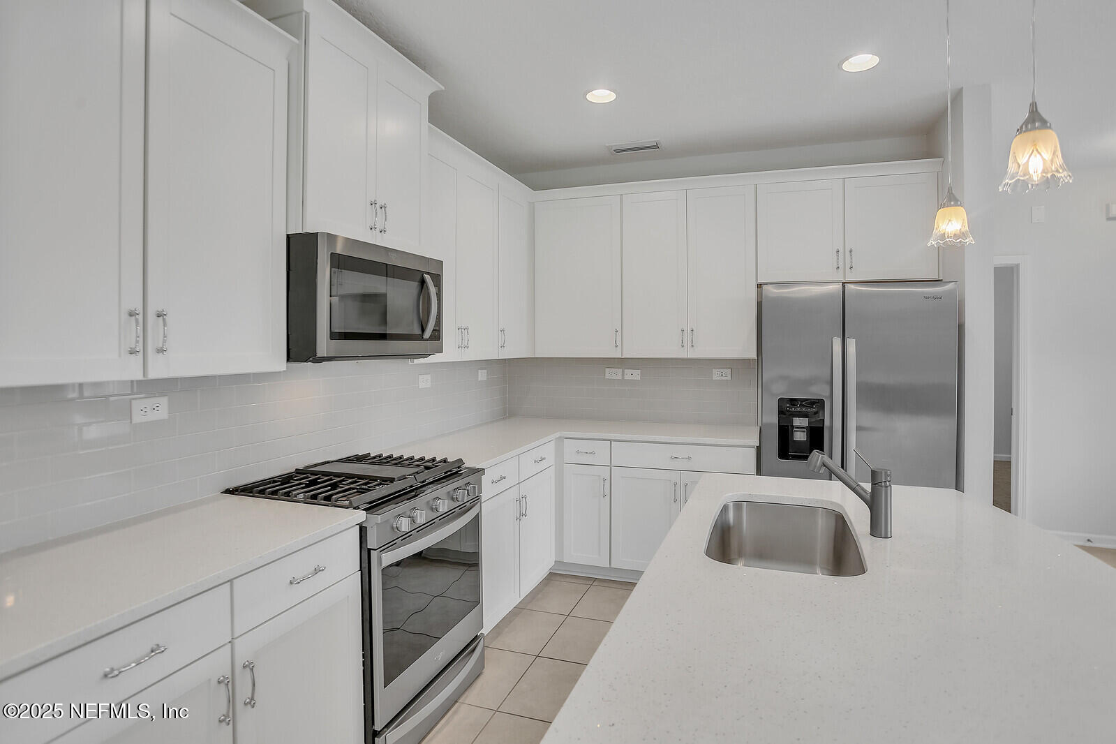 133 Leeward Island Drive St. Augustine, FL 32080 - Photo 17 of 48 a kitchen with granite countertop a refrigerator sink and microwave
