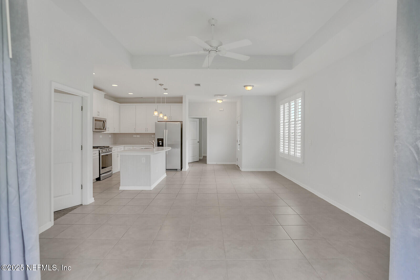 133 Leeward Island Drive St. Augustine, FL 32080 - Photo 18 of 48 a view of a kitchen with refrigerator and white cabinets