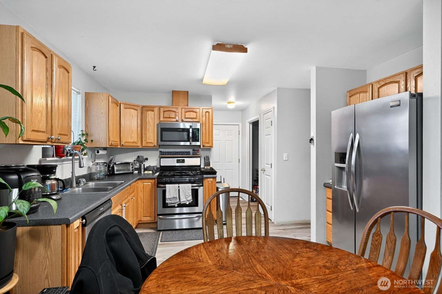 2972 Brook Lane Sedro-Woolley, WA 98284 - Photo 12 of 35 a kitchen with stainless steel appliances granite countertop a refrigerator a stove top oven a sink dishwasher and wooden cabinets with a dining table