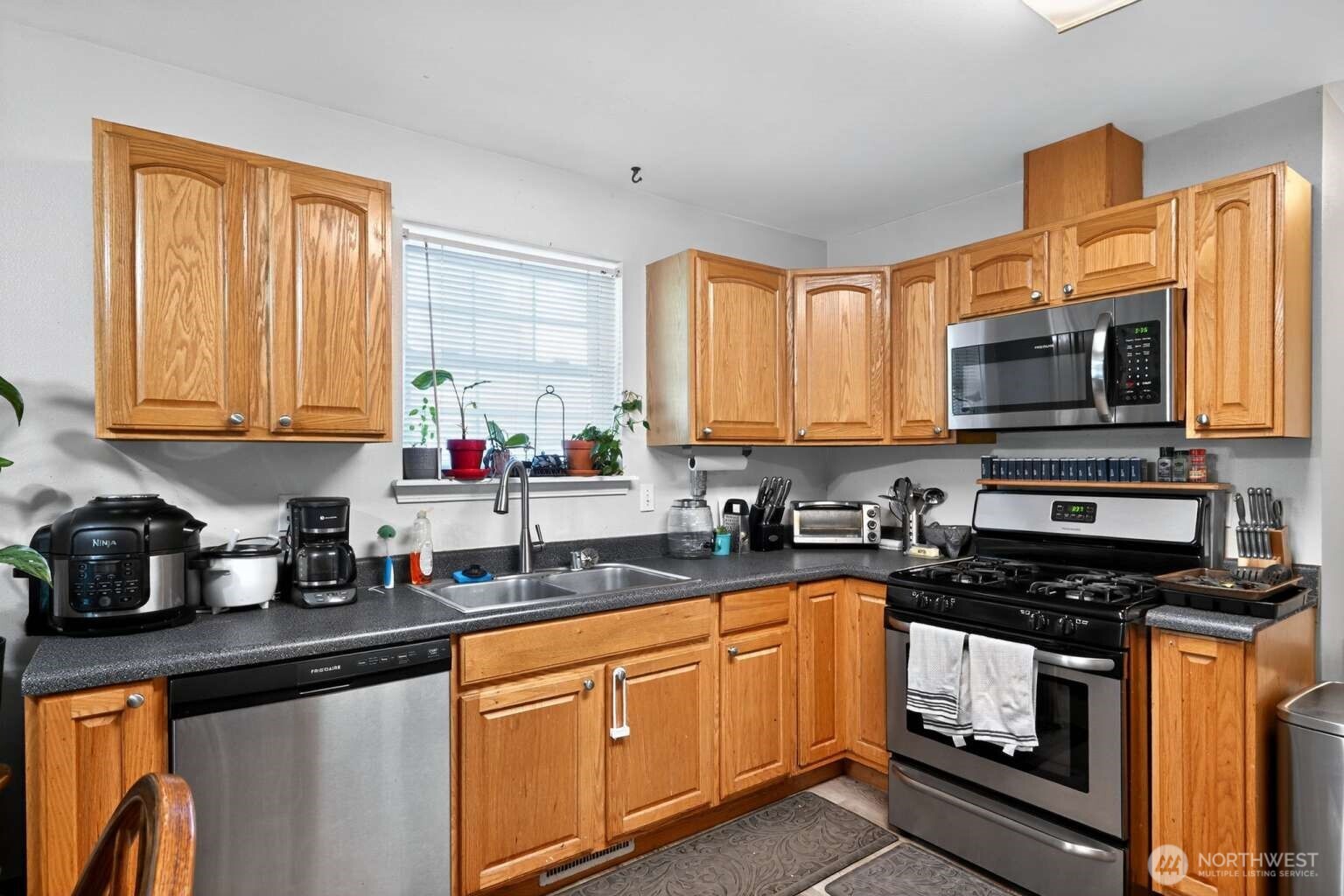 2972 Brook Lane Sedro-Woolley, WA 98284 - Photo 10 of 35 a kitchen with stainless steel appliances granite countertop a stove a sink dishwasher and a microwave oven with cabinets