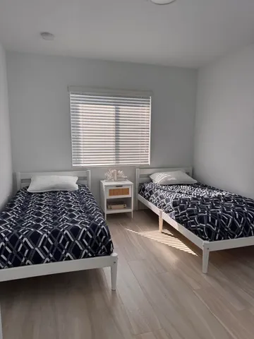 a bed sitting in a bedroom next to a window