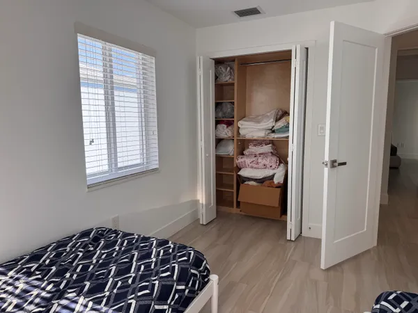 a bedroom with a bed and wooden floor