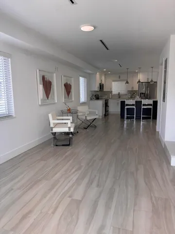 a living room with furniture and kitchen view