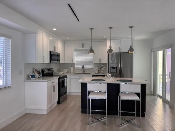 a kitchen with white cabinets and stainless steel appliances