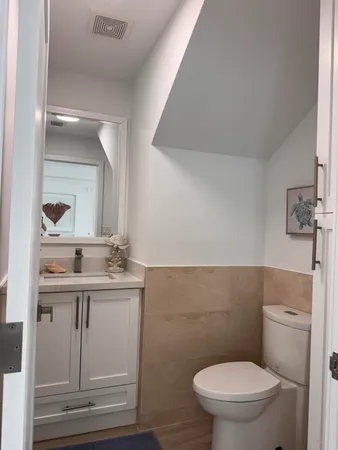 a bathroom with a granite countertop toilet sink and mirror