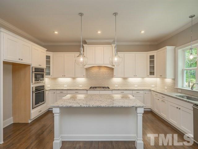 1425 Starry Night Court Raleigh, NC 27613 - Photo 9 of 33 a kitchen with kitchen island white cabinets and stainless steel appliances