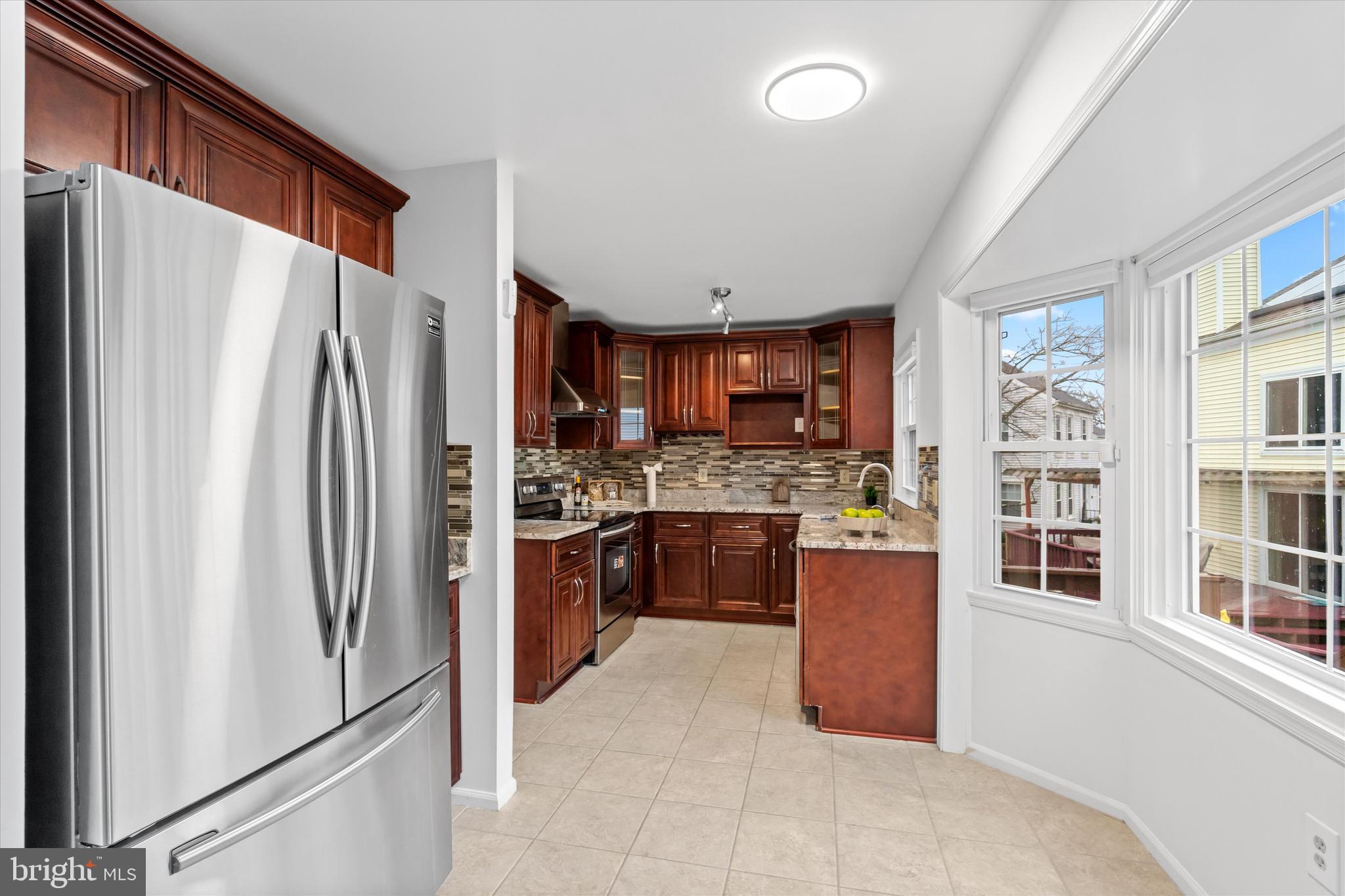 14810 Cherry Leaf Terrace Silver Spring, MD 20906 - Photo 12 of 35 a kitchen with stainless steel appliances granite countertop a refrigerator and a stove top oven
