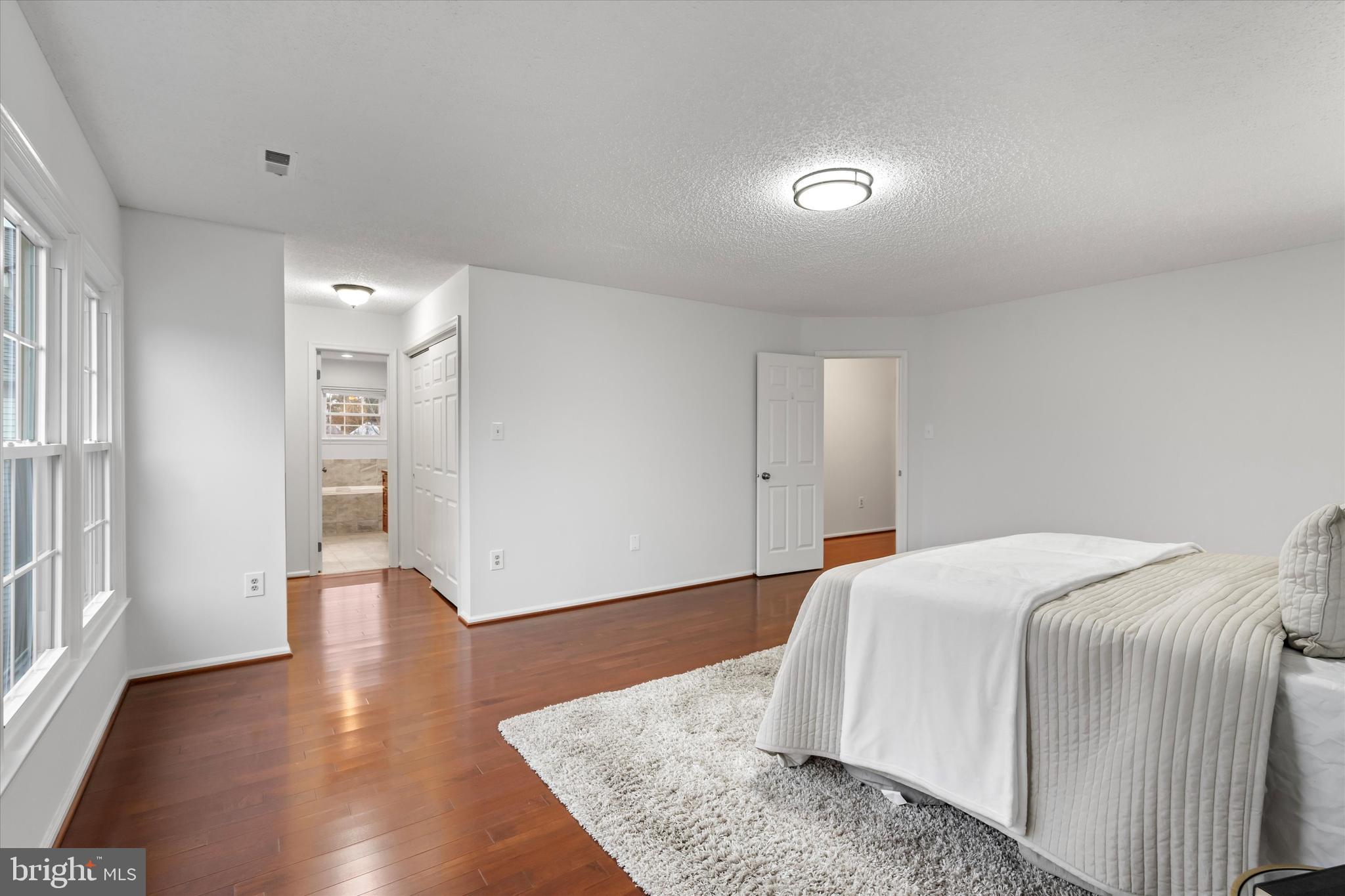 14810 Cherry Leaf Terrace Silver Spring, MD 20906 - Photo 13 of 35 a spacious bedroom with a bed and wooden floor