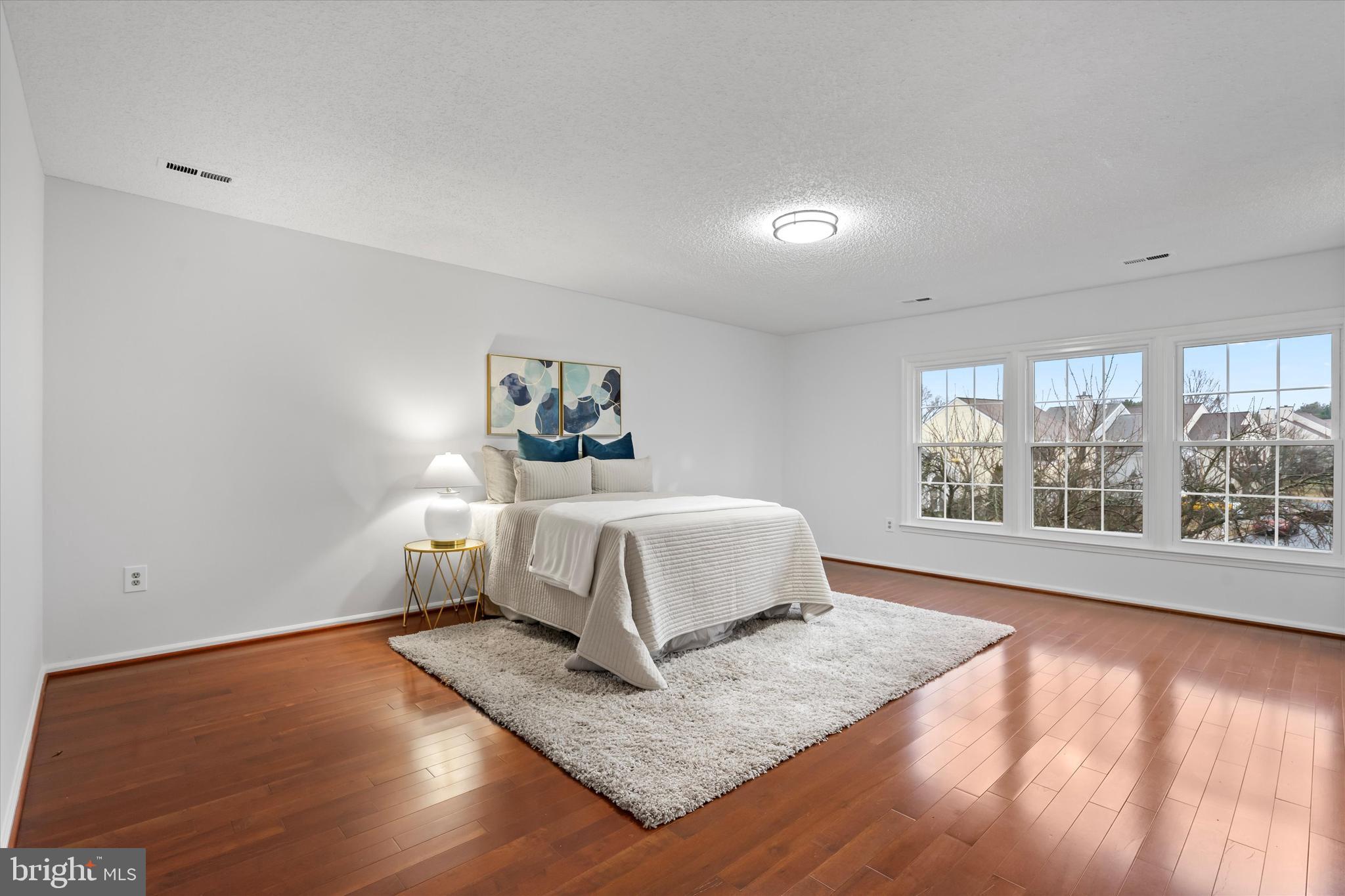 14810 Cherry Leaf Terrace Silver Spring, MD 20906 - Photo 14 of 35 a bedroom with a bed and wooden floor