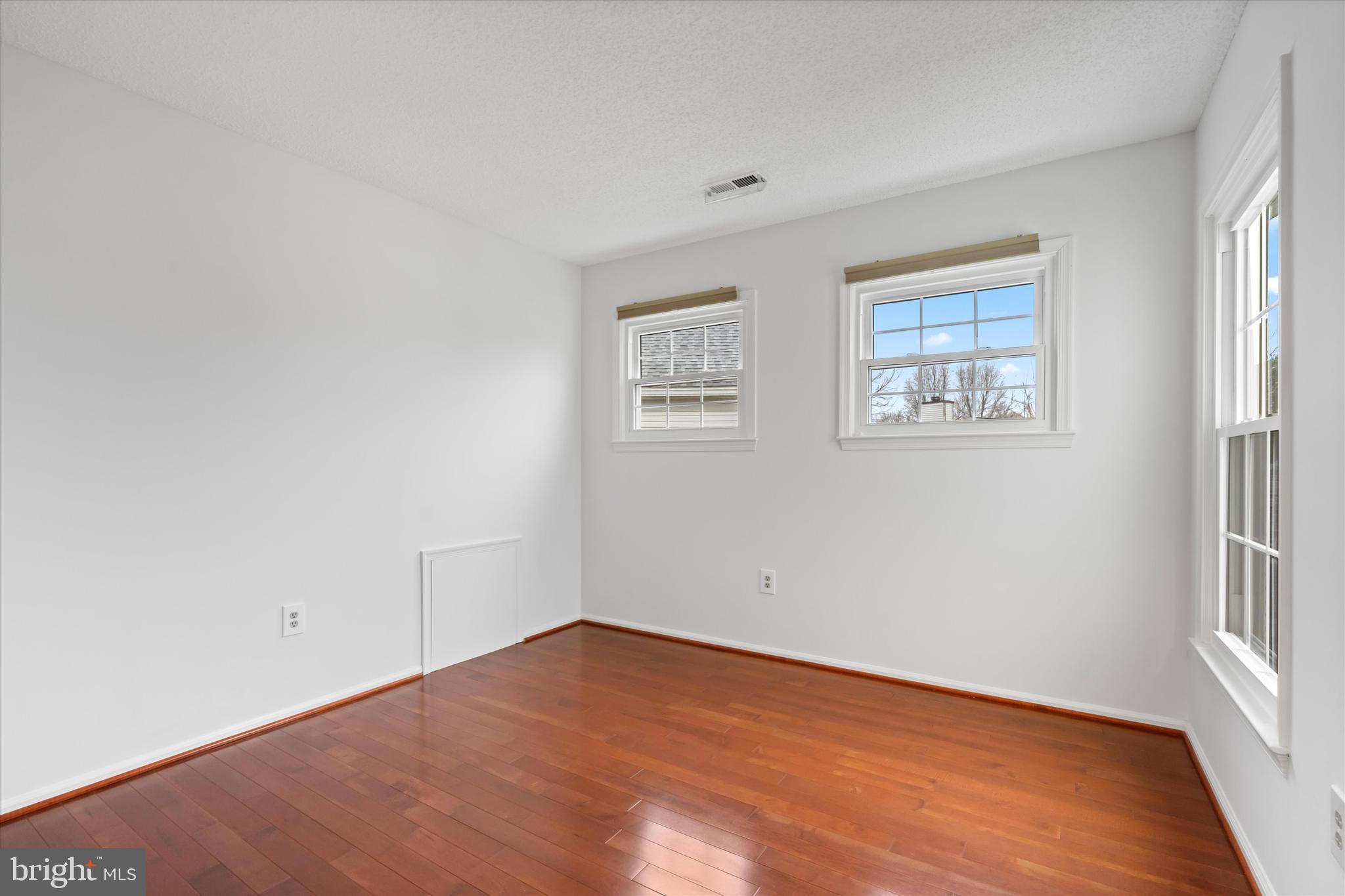 14810 Cherry Leaf Terrace Silver Spring, MD 20906 - Photo 20 of 35 an empty room with wooden floor and windows