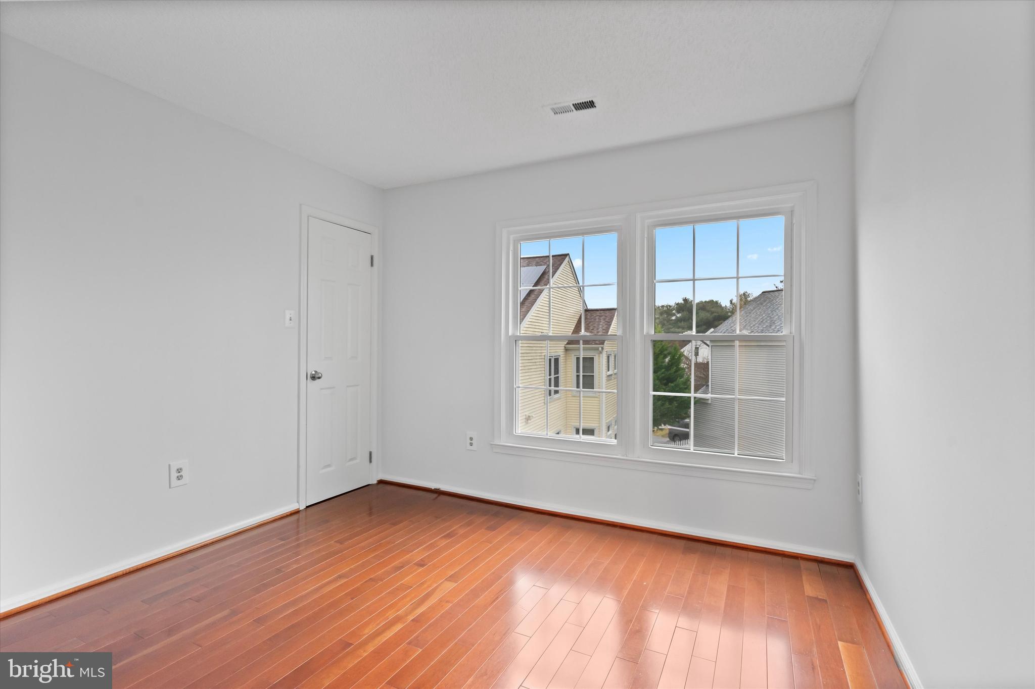 14810 Cherry Leaf Terrace Silver Spring, MD 20906 - Photo 21 of 35 an empty room with wooden floor and windows