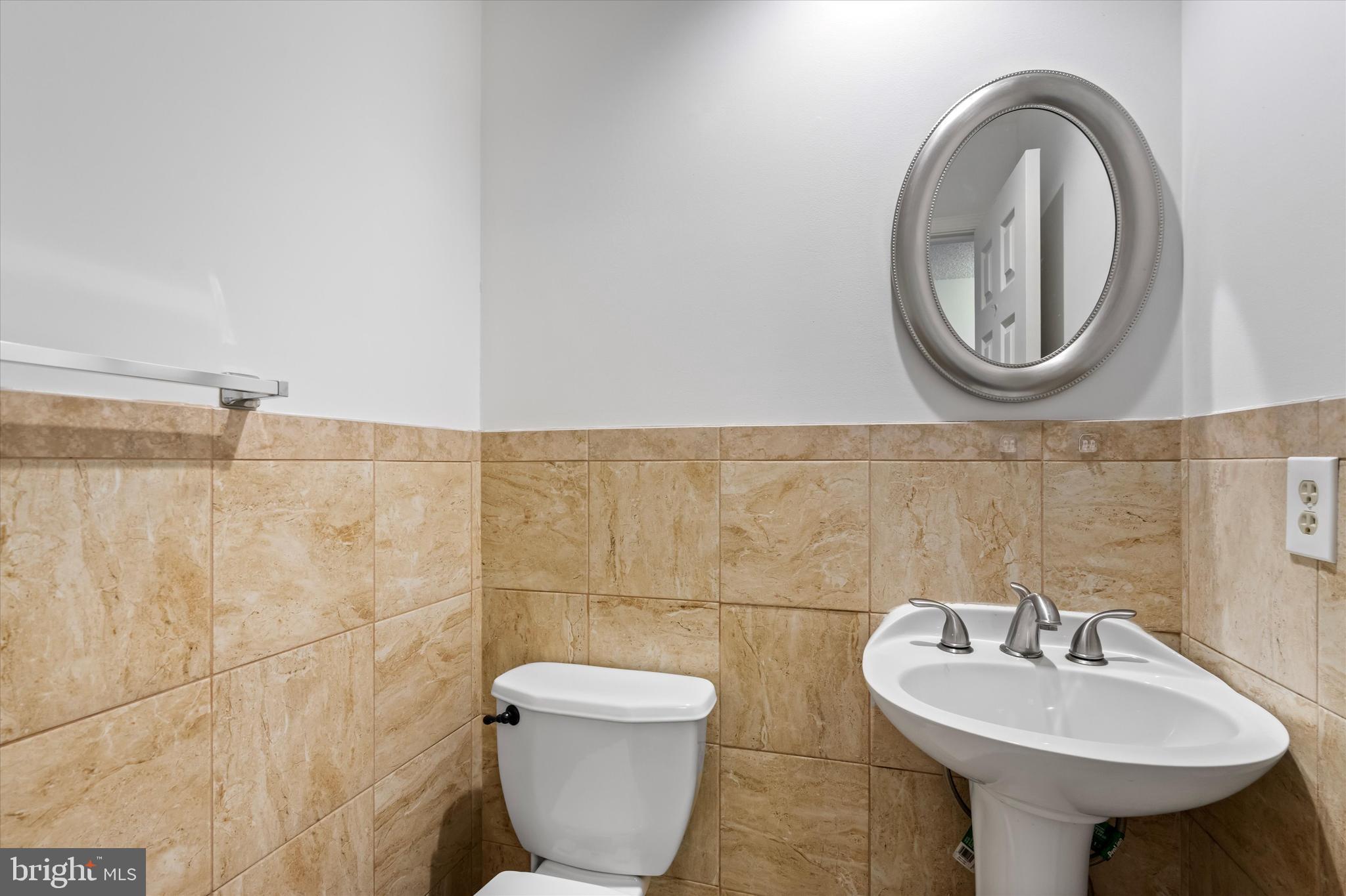 14810 Cherry Leaf Terrace Silver Spring, MD 20906 - Photo 22 of 35 a bathroom with a toilet a sink and a mirror