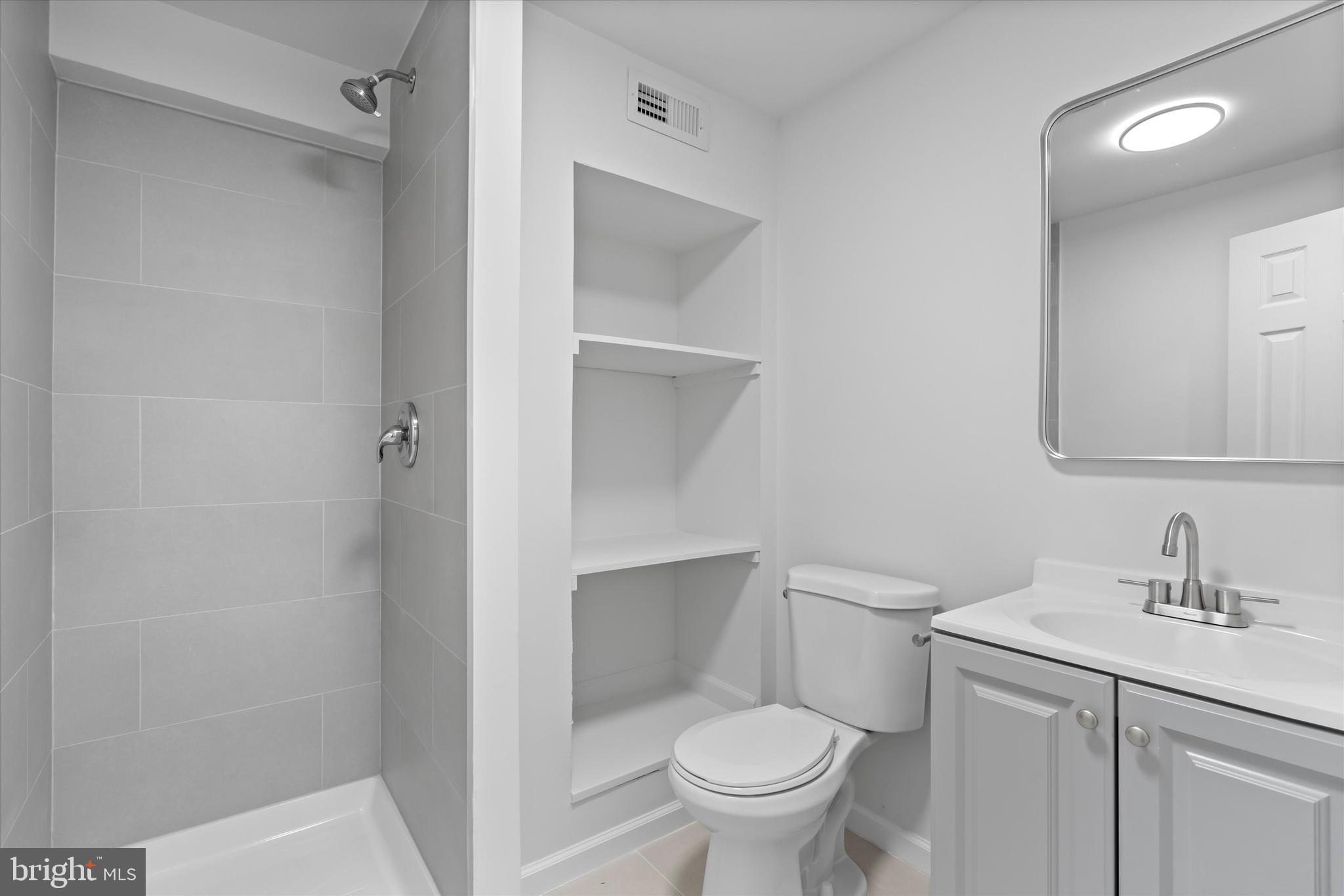 14810 Cherry Leaf Terrace Silver Spring, MD 20906 - Photo 25 of 35 a bathroom with a toilet sink and mirror
