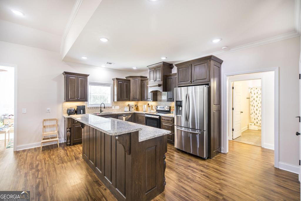 219 Rowland Circle Byron, GA 31008 - Photo 13 of 47 a kitchen with stainless steel appliances granite countertop a refrigerator a sink dishwasher a stove with wooden floors and a fireplace