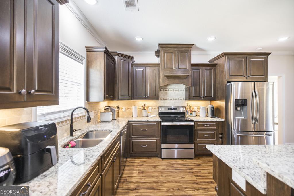 219 Rowland Circle Byron, GA 31008 - Photo 17 of 47 a kitchen with stainless steel appliances granite countertop a sink stove and refrigerator