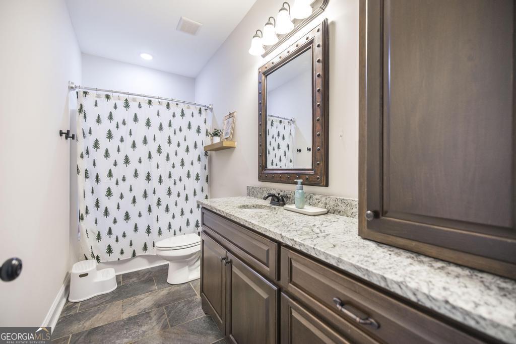 219 Rowland Circle Byron, GA 31008 - Photo 26 of 47 a bathroom with a granite countertop toilet sink and mirror