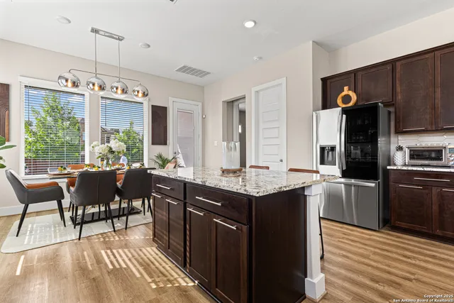 a kitchen with kitchen island granite countertop a sink stove and refrigerator