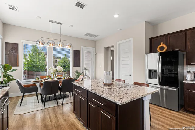 a kitchen with a table chairs refrigerator and cabinets