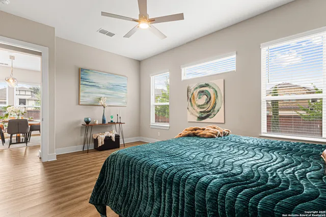 a bedroom with a bed and dresser with wooden floor