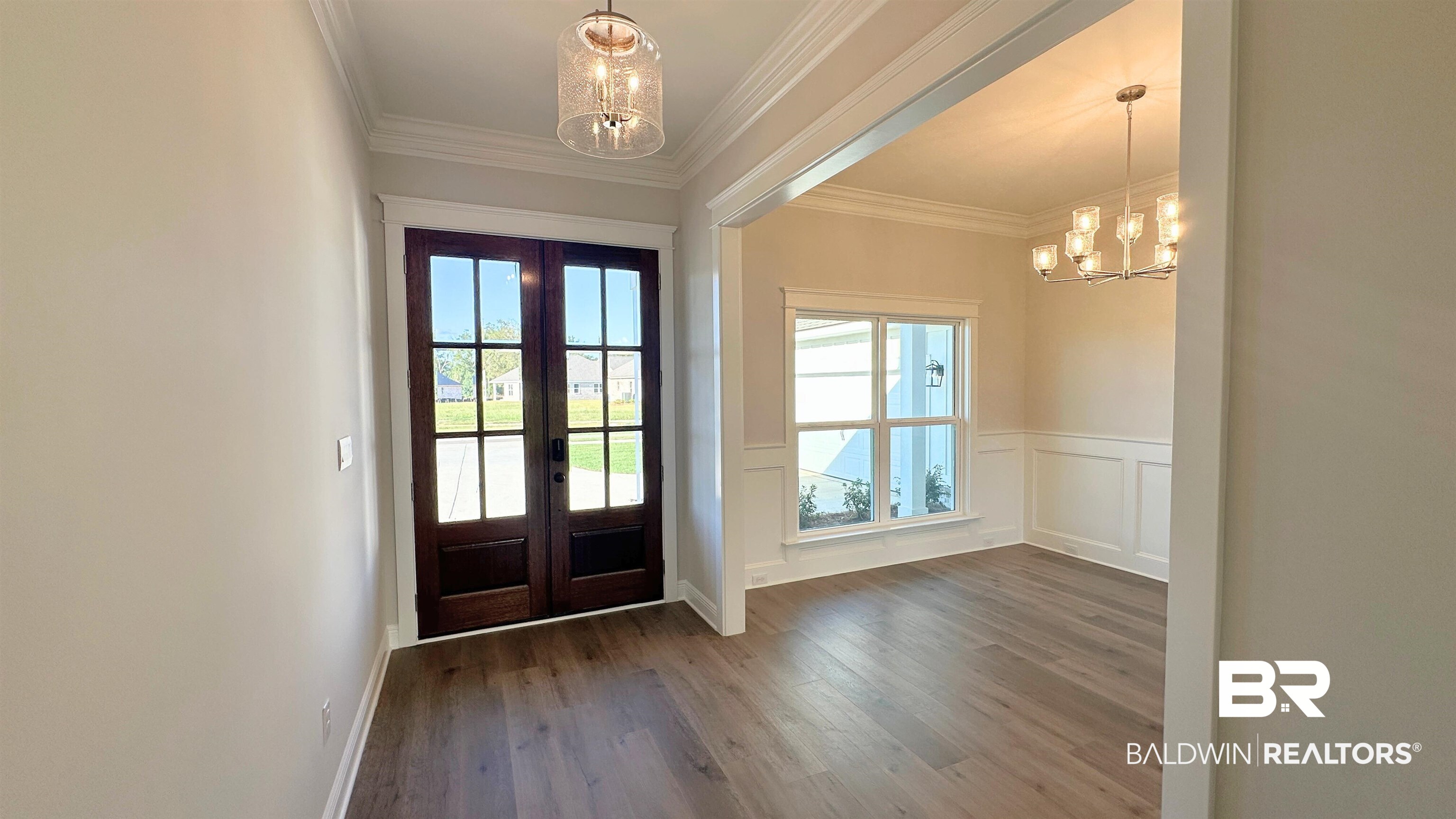 126 Daybreak Trail Fairhope, AL 36532 - Photo 3 of 34 Doorway to outside with a chandelier, ornamental molding, wood finished floors, a wainscoted wall, and french doors