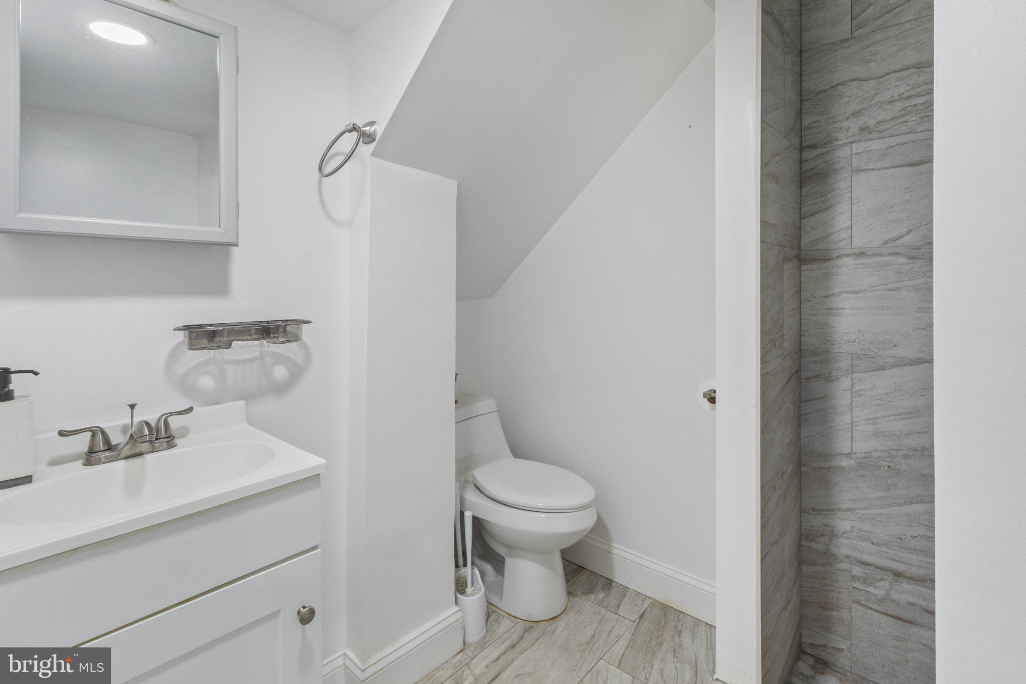 130 West Edgevale Road Baltimore, MD 21225 - Photo 29 of 37 a bathroom with a sink toilet and a mirror