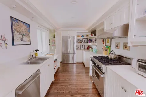 a kitchen with stainless steel appliances a stove a sink and a refrigerator