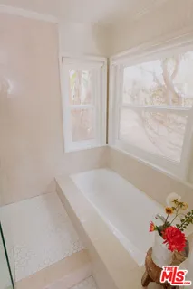 a bath tub sitting in a bathroom next to a window