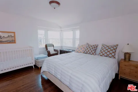 a bedroom with two beds and a baby crib