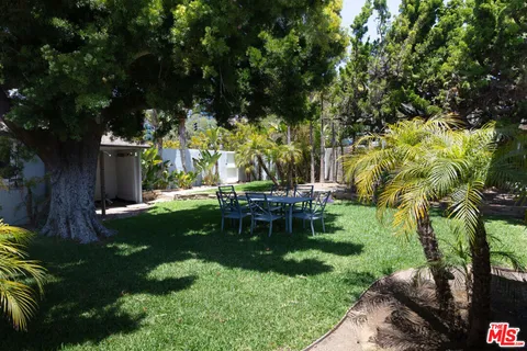 a view of an house with backyard and furniture