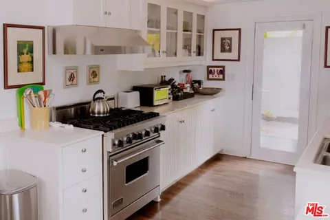 a kitchen with stainless steel appliances granite countertop white cabinets and a stove